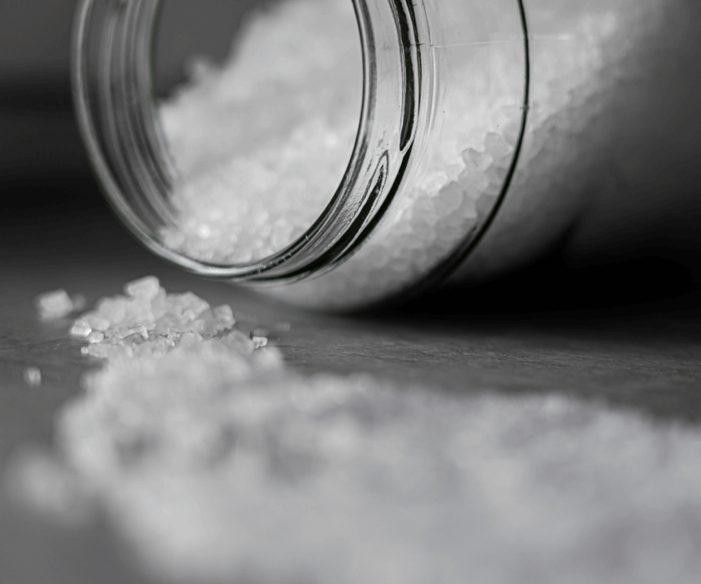 Photo of a jar tipped over with while crystals spilling out.