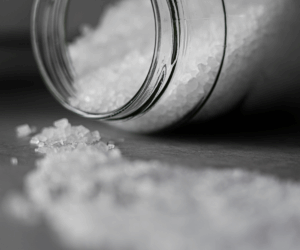 Photo of a jar tipped over with while crystals spilling out.