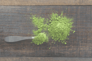 A pile of green powder on a table with small spoon